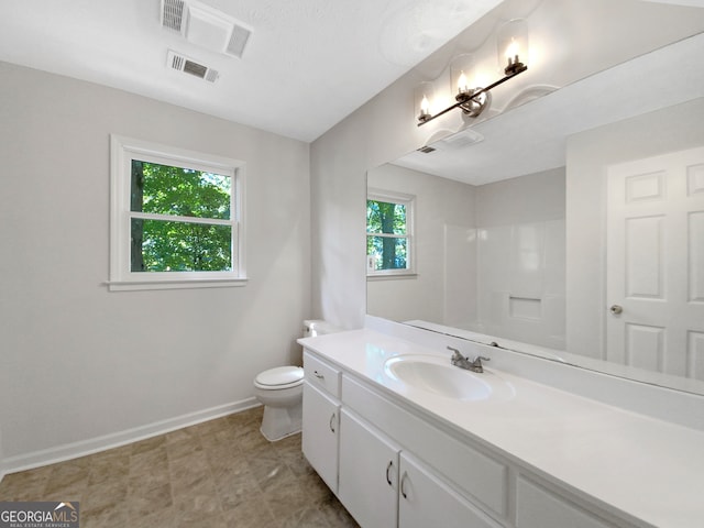 bathroom with vanity, toilet, and a wealth of natural light