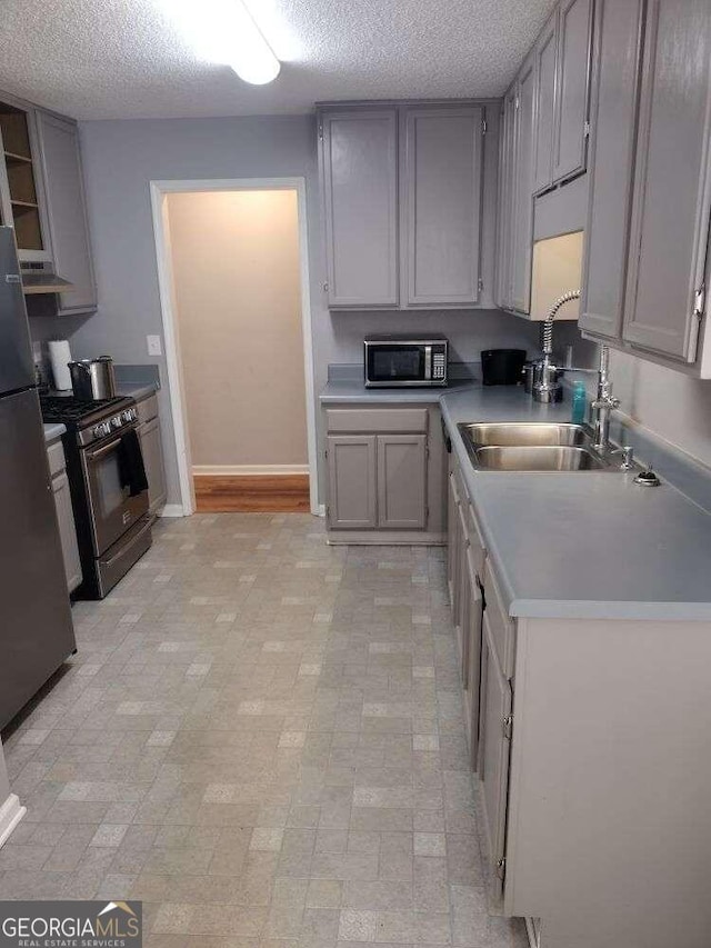 115 Elberta St, Mcdonough, GA 30253 - kitchen with gray cabinets, a textured ceiling, appliances with stainless steel finishes, and a sink