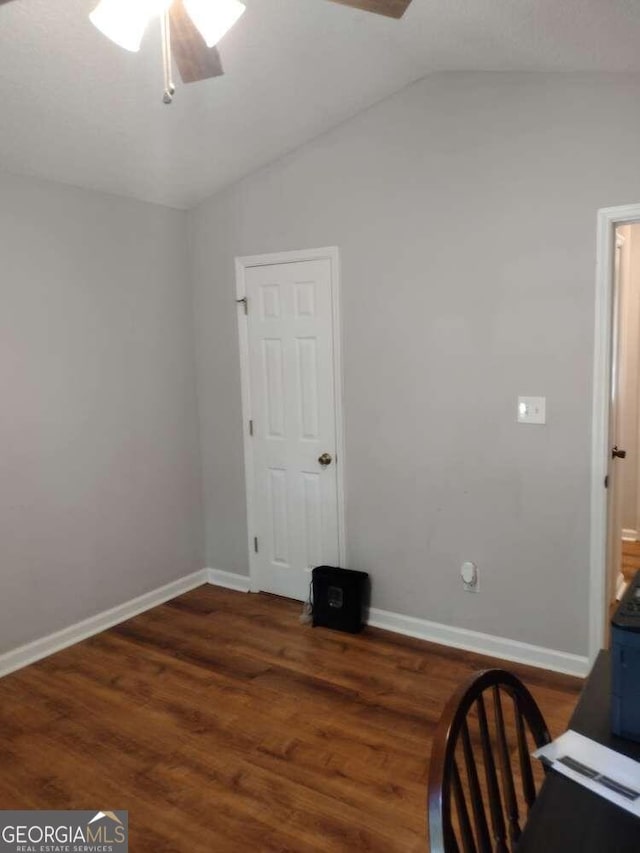 unfurnished office featuring lofted ceiling, dark hardwood / wood-style flooring, and ceiling fan