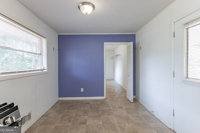 spare room featuring crown molding and a healthy amount of sunlight