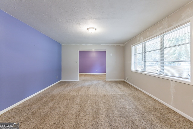 carpeted spare room featuring a textured ceiling