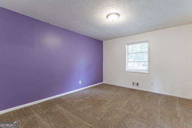 carpeted empty room with a textured ceiling