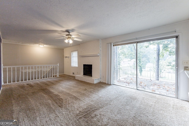 unfurnished living room with carpet flooring, a fireplace, a textured ceiling, and ceiling fan