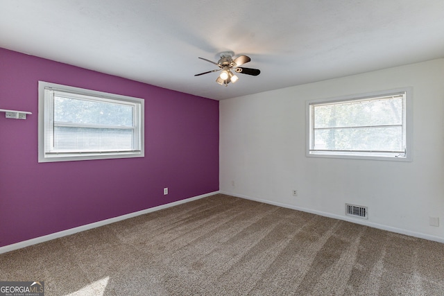 carpeted empty room with a healthy amount of sunlight and ceiling fan