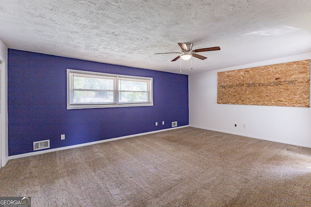 spare room featuring carpet, a textured ceiling, and ceiling fan