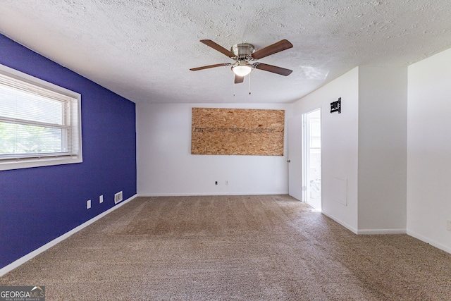 unfurnished room with a textured ceiling, carpet flooring, and ceiling fan