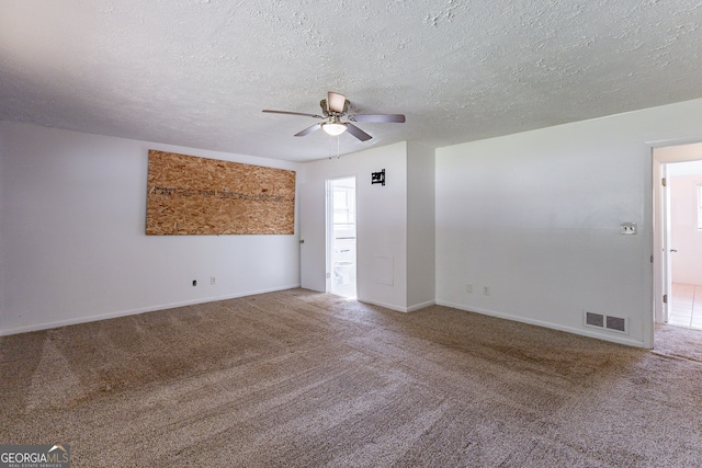 carpeted spare room with a textured ceiling and ceiling fan