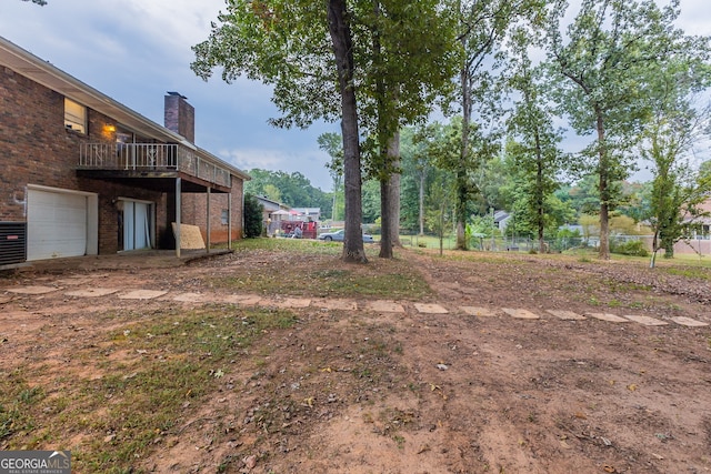 view of yard with a balcony and a garage