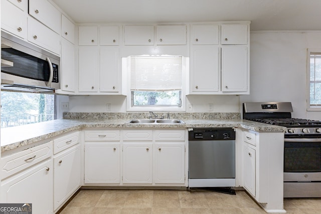 kitchen with appliances with stainless steel finishes, a healthy amount of sunlight, and sink