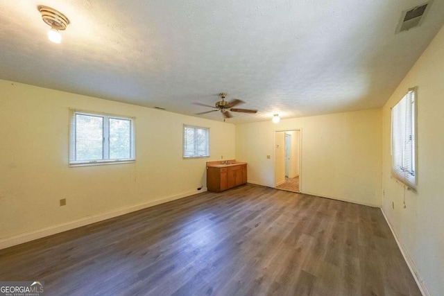 spare room featuring ceiling fan, dark hardwood / wood-style flooring, a textured ceiling, and sink