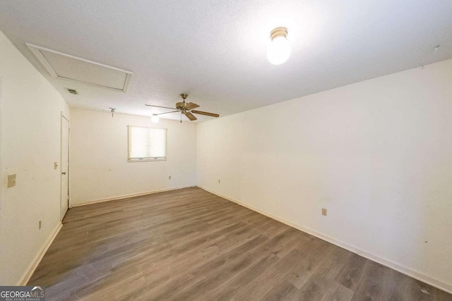 spare room with dark hardwood / wood-style flooring and ceiling fan