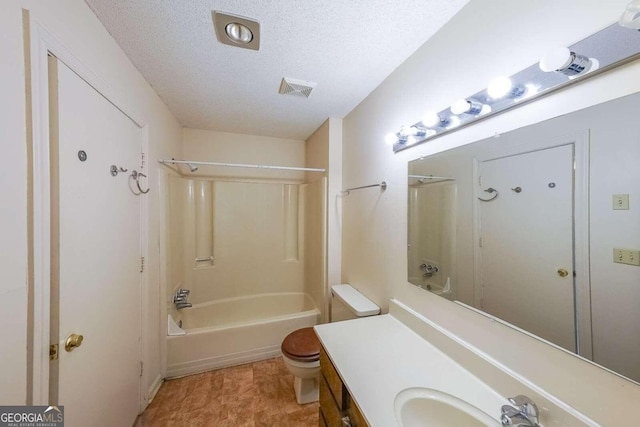 full bathroom with  shower combination, vanity, a textured ceiling, and toilet