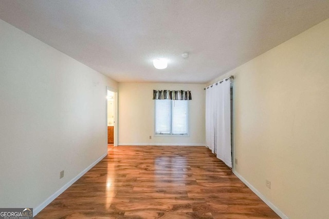 unfurnished room with hardwood / wood-style flooring