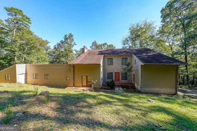 rear view of property with a lawn