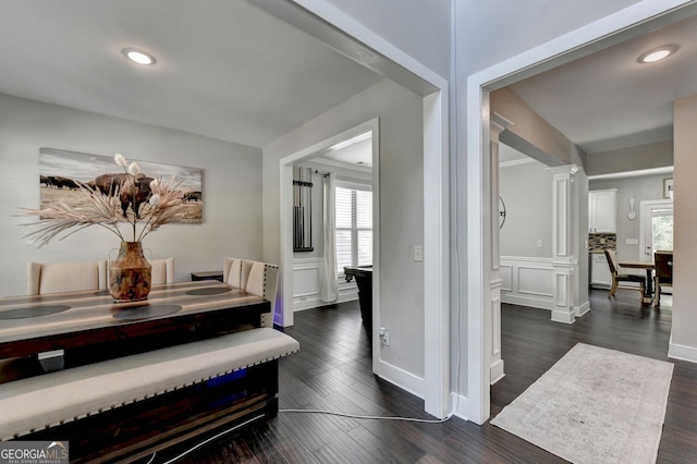 corridor featuring ornate columns and dark hardwood / wood-style flooring