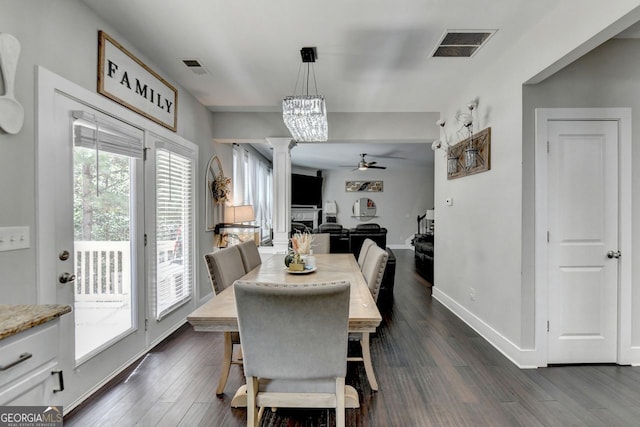 dining room featuring ceiling fan, ornate columns, and dark wood-type flooring