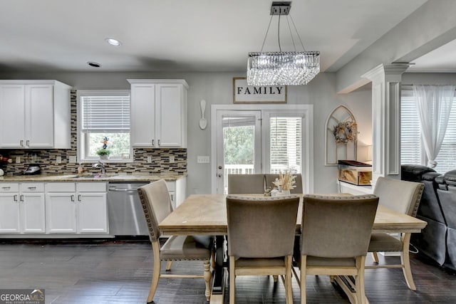 dining room with ornate columns, dark hardwood / wood-style floors, a chandelier, and sink