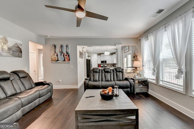 living room with ceiling fan and dark hardwood / wood-style flooring