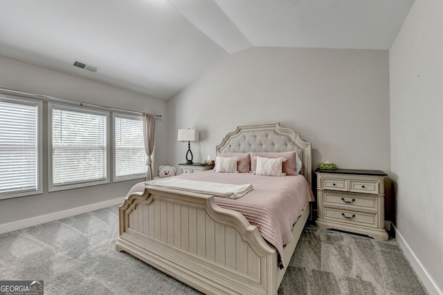 bedroom with light colored carpet and vaulted ceiling