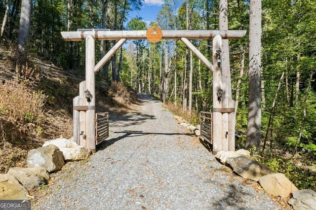 view of gate featuring a forest view