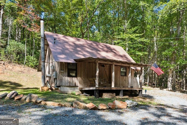 view of front facade with a wooded view and an outdoor structure