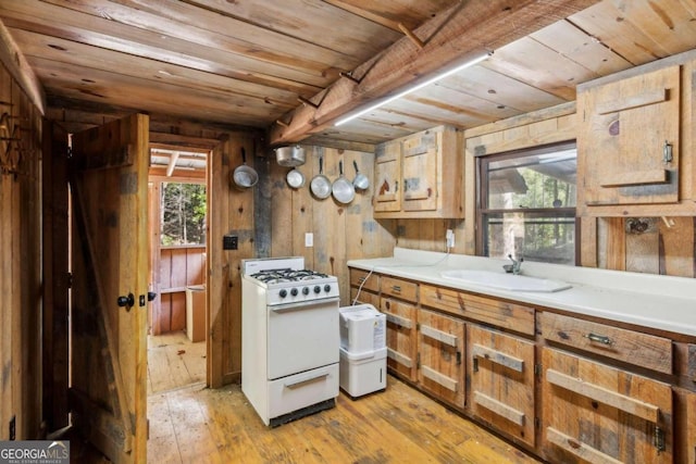 kitchen featuring wood ceiling, white range with gas cooktop, light wood-style flooring, and a sink