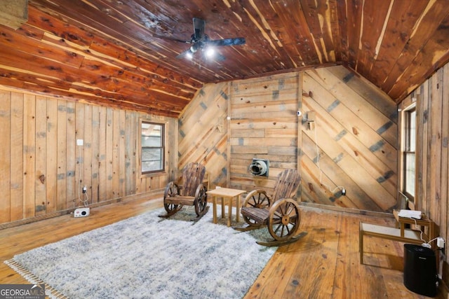 living area with lofted ceiling, wood ceiling, wood walls, and hardwood / wood-style flooring