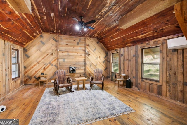 unfurnished room with hardwood / wood-style floors, wood walls, a wall unit AC, and wooden ceiling