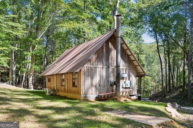 view of side of home with an outdoor structure and a lawn