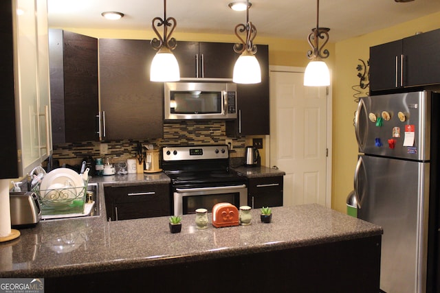 kitchen featuring stainless steel appliances, pendant lighting, and tasteful backsplash