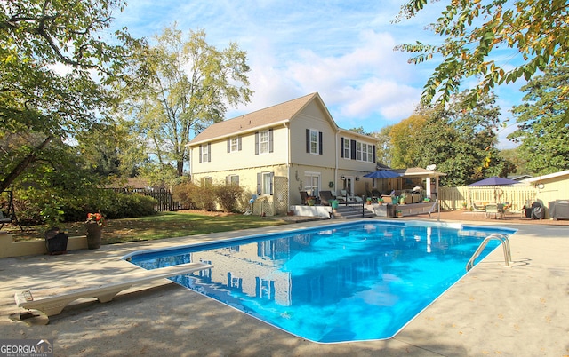 view of pool with a diving board and a patio