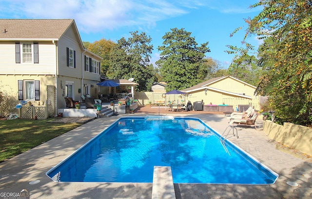 view of swimming pool featuring a patio and a diving board