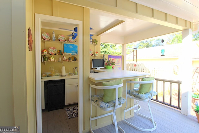 exterior space with a kitchen breakfast bar, hardwood / wood-style flooring, and white cabinetry