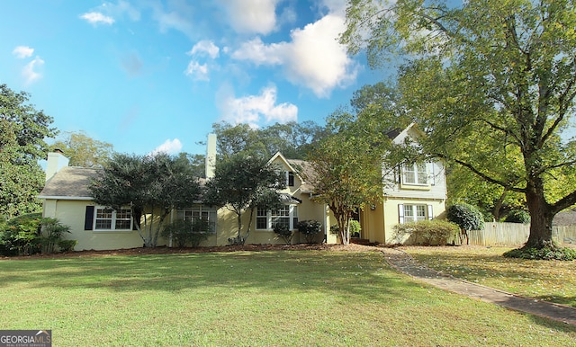 view of property hidden behind natural elements with a front yard