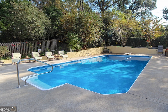 view of pool with a diving board and a patio area