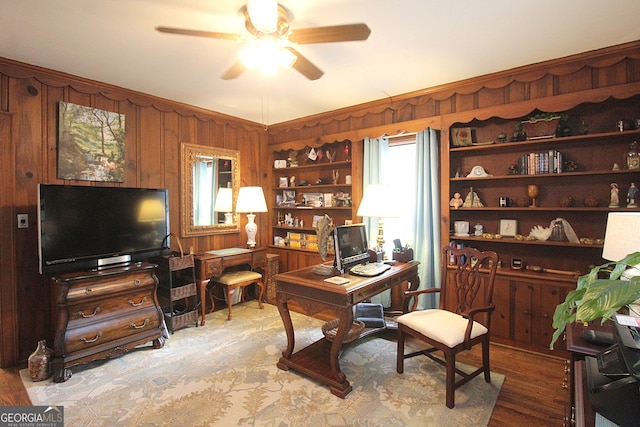 office area with wooden walls, hardwood / wood-style floors, and ceiling fan