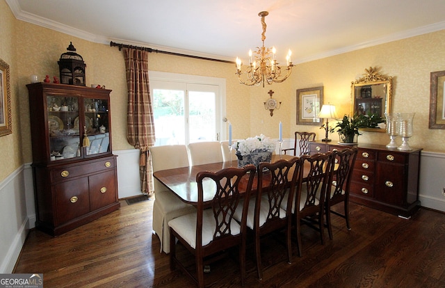 dining space with ornamental molding, a chandelier, and dark hardwood / wood-style floors