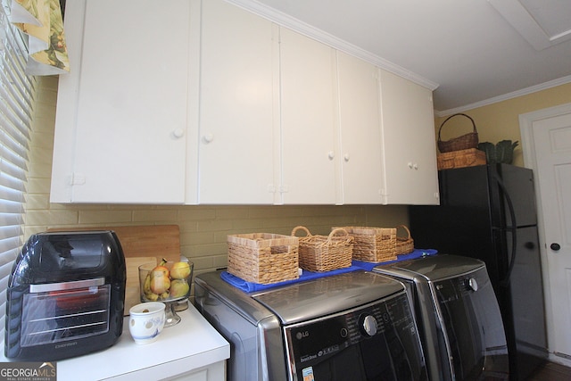 clothes washing area featuring cabinets, separate washer and dryer, and crown molding