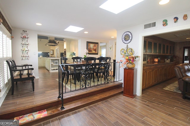 dining area featuring a skylight and hardwood / wood-style floors