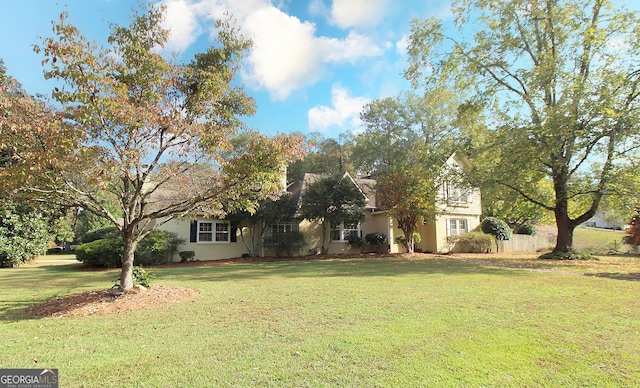 view of property hidden behind natural elements featuring a front yard