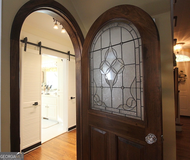 interior details with a barn door and hardwood / wood-style flooring