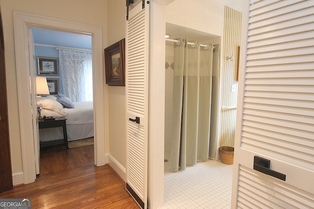 hall featuring a barn door and dark hardwood / wood-style floors