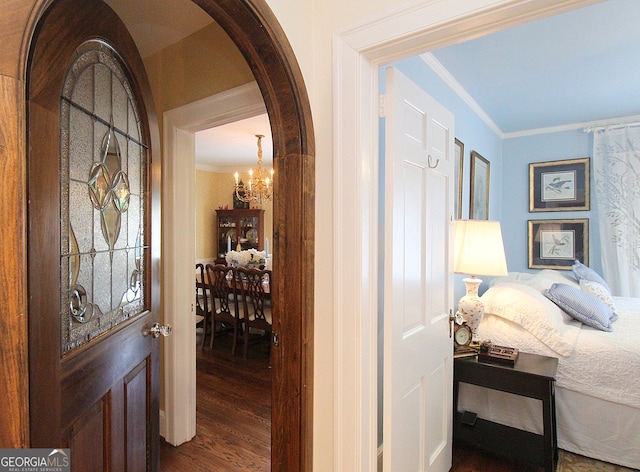 interior space featuring hardwood / wood-style flooring, a notable chandelier, and ornamental molding