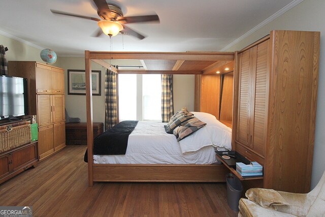 bedroom featuring dark wood-type flooring, ceiling fan, a closet, and crown molding