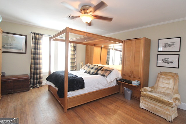 bedroom featuring ornamental molding, hardwood / wood-style floors, and ceiling fan