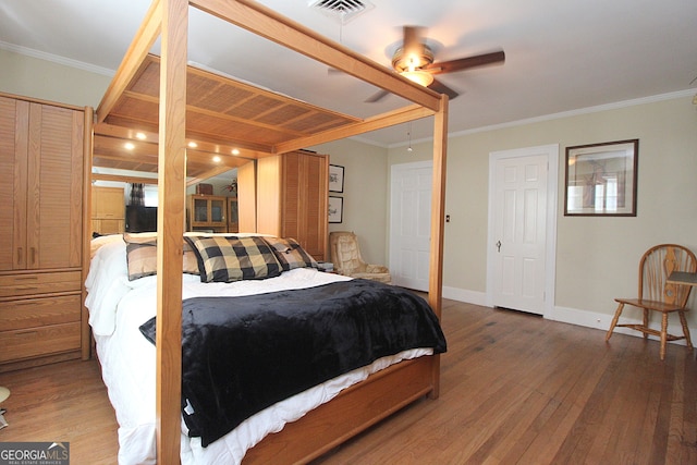 bedroom with ornamental molding, ceiling fan, and dark hardwood / wood-style floors