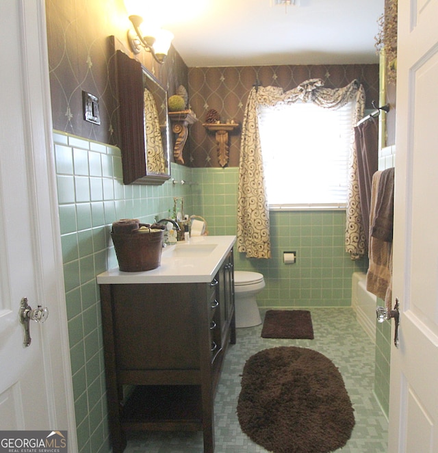 full bathroom featuring vanity, toilet, tile walls, and shower / washtub combination