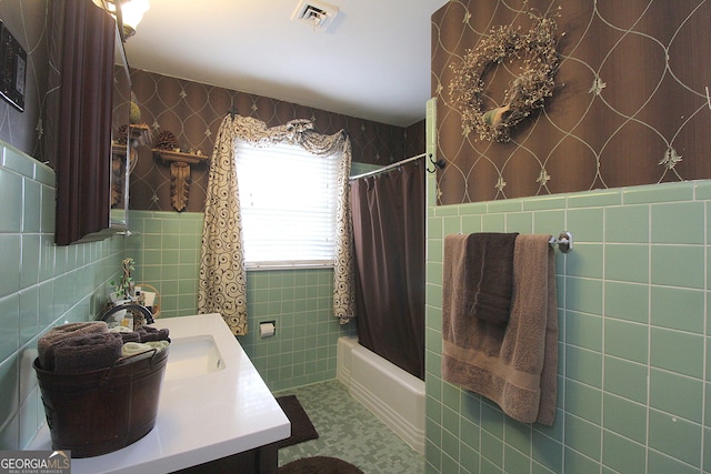 bathroom featuring tile walls, vanity, and shower / bathtub combination with curtain