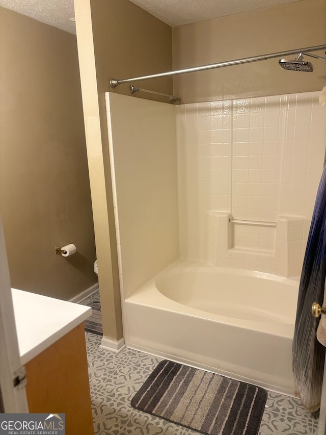 bathroom with tile patterned flooring, vanity, washtub / shower combination, and a textured ceiling