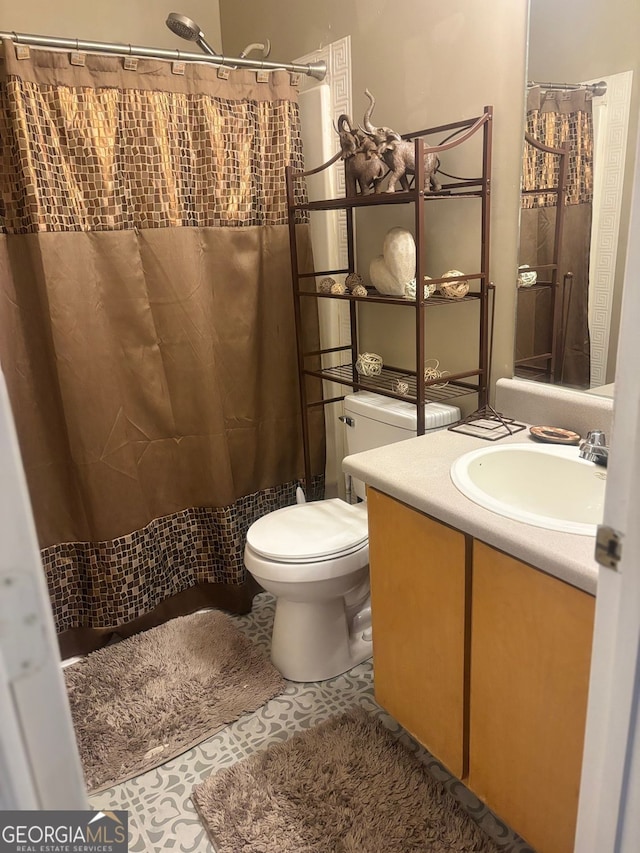 bathroom featuring tile patterned floors, a shower with curtain, vanity, and toilet